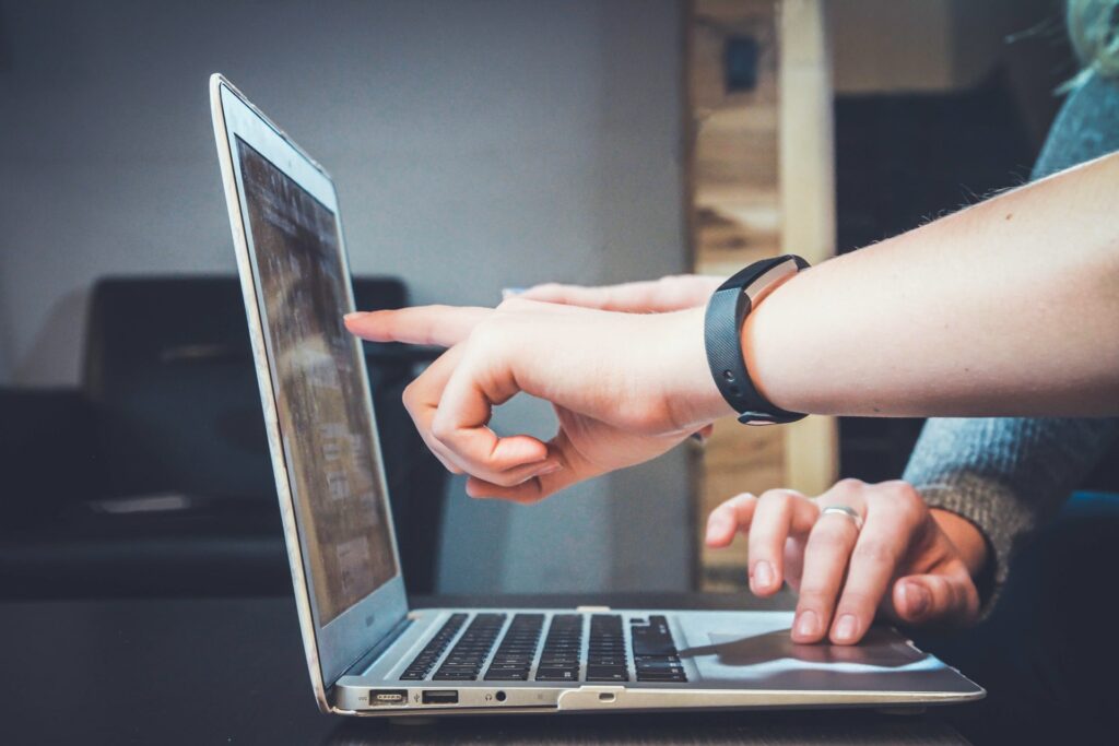 Hand pointing at a computer sceren